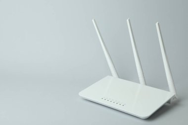 Gri arkaplanda harici antenleri olan Wi-Fi yönlendirici
