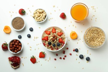 Beyaz arka planda yemek pişirmek için bir kase yulaf ezmesi ve malzeme.