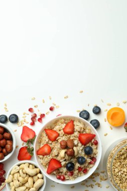 Beyaz arka planda yemek pişirmek için bir kase yulaf ezmesi ve malzeme.