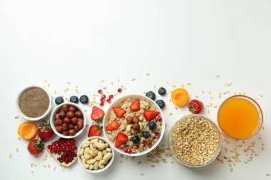 Beyaz arka planda yemek pişirmek için bir kase yulaf ezmesi ve malzeme.