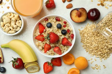 Beyaz arka planda yemek pişirmek için bir kase yulaf ezmesi ve malzeme.