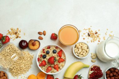 Beyaz arka planda yemek pişirmek için bir kase yulaf ezmesi ve malzeme.