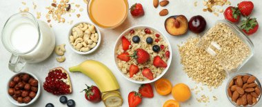 Beyaz arka planda yemek pişirmek için bir kase yulaf ezmesi ve malzeme.