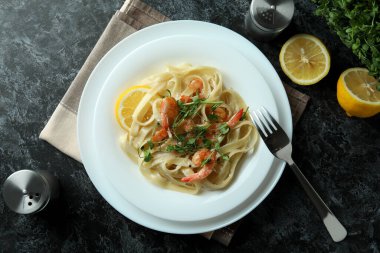 Siyah dumanlı masada karides makarna ile lezzetli yemek kavramı