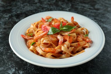 Siyah dumanlı masada karides makarna ile lezzetli yemek kavramı