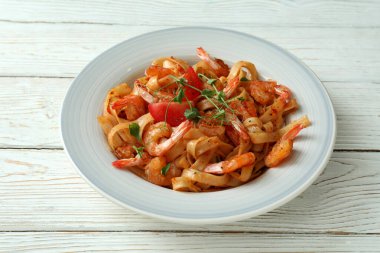 Beyaz ahşap masada karides makarna pişirme kavramı