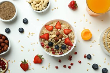 Beyaz arka planda yemek pişirmek için bir kase yulaf ezmesi ve malzeme.