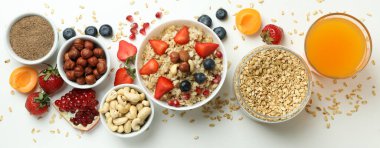 Beyaz arka planda yemek pişirmek için bir kase yulaf ezmesi ve malzeme.