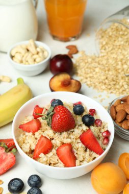 Beyaz arka planda yemek pişirmek için bir kase yulaf ezmesi ve malzeme.