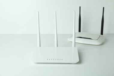 Beyaz arkaplanda harici antenleri olan Wi-Fi yönlendiricileri