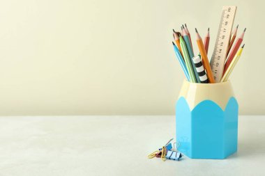 Beyaz desenli masa üzerinde kırtasiye malzemesi olan tutucu