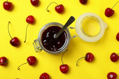 Sarı arka planda kiraz reçeli ve malzemeler