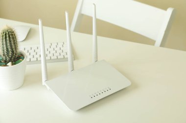 Beyaz masadaki Wi-fi yönlendiricili işyeri