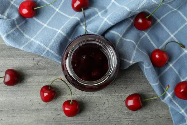 Kirschmarmelade Und Zutaten Auf Grau Strukturiertem Tisch — Stockfoto