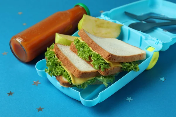 Pudełko Lunch Smacznym Jedzeniem Niebieskim Tle — Zdjęcie stockowe