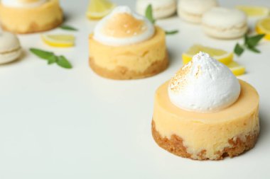 Lemon cupcakes, macaroons and ingredients on white background