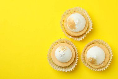 Lemon cupcakes on yellow background, space for text