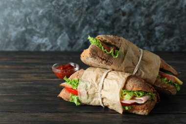 Ciabatta sandviçi ve ahşap masada sos.