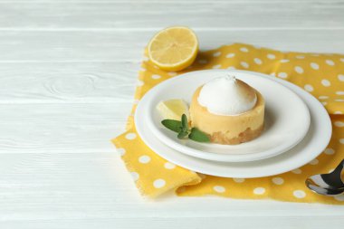 Concept of tasty breakfast with lemon cupcake on white wooden table