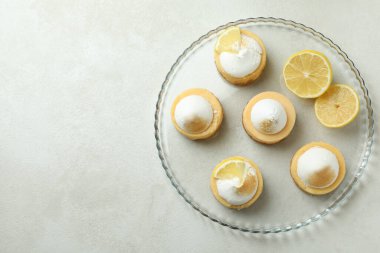 Tasty lemon cupcakes on tray on white textured table