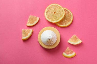 Lemon cupcake and lemon slices on pink background