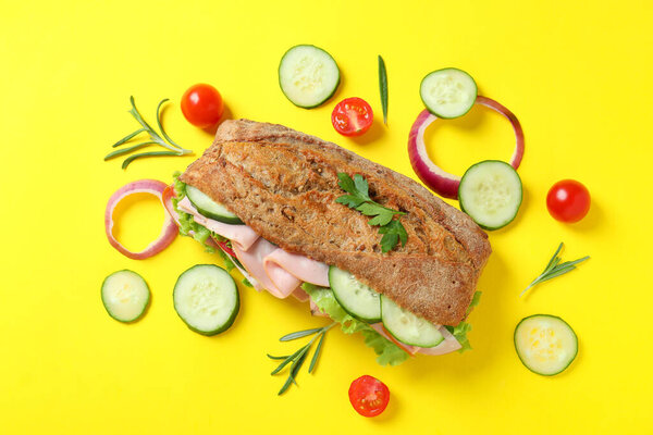 Ciabatta sandwich and ingredients on yellow background