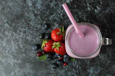 Smoothie ve malzemeler siyah dumanlı masada.