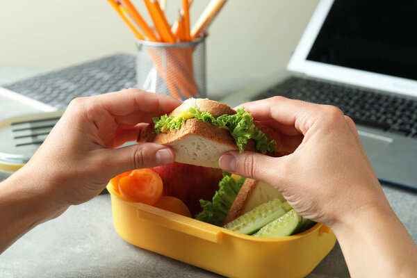 Рабочее место есть с женскими руками держать сэндвич, закрыть