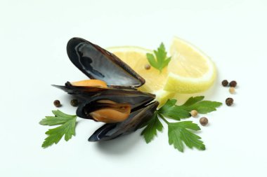 Beyaz arka planda limonlu midye, maydanoz ve biber.