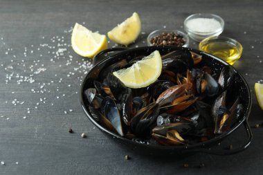 Koyu ahşap masada taze midyeli tava.