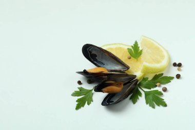 Beyaz arka planda limonlu midye, maydanoz ve biber.