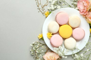 Açık gri arka planda dişi aksesuarlar ve badem kurabiyeleri