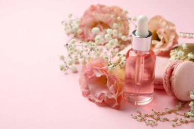 Pembe arka planda kadın aksesuarları ve kurabiyeler.