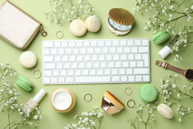 Yeşil arka planda kadın aksesuarları ve kurabiyeler