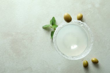 Beyaz desenli masada bir bardak kokteyl ve malzemeler.