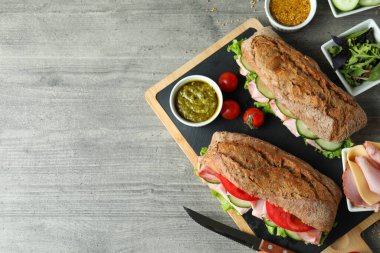 Ciabatta sandviçleri ve gri desenli masadaki lezzetli yemek kavramı.