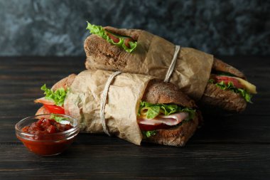 Ciabatta sandviçi ve ahşap masada sos.