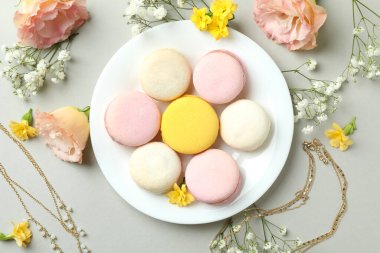 Açık gri arka planda dişi aksesuarlar ve badem kurabiyeleri