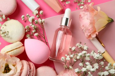 Pembe arka planda kadın aksesuarları ve kurabiyeler.