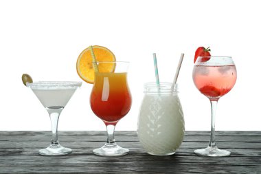 Beyaz arka planda izole ahşap masada farklı kokteyller.