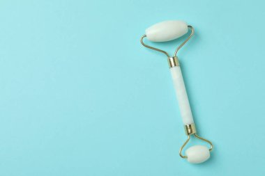 Mavi arka planda beyaz yüz masajı silindiri