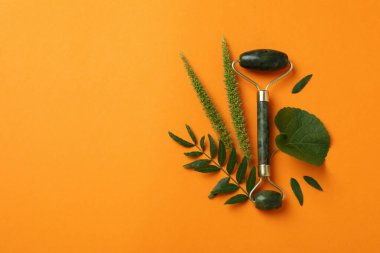 Yeşil yüz silindiri ve turuncu arkaplanda yapraklar