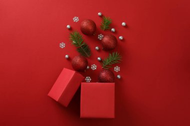 Kırmızı arka planda hediye kutusu ve Noel mücevherleri