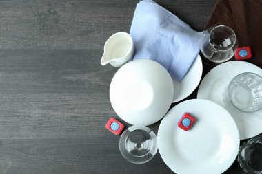 Koyu ahşap masada bulaşık deterjanı aksesuarları.