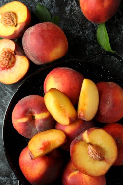 Siyah dumanlı masada şeftali meyveli kase