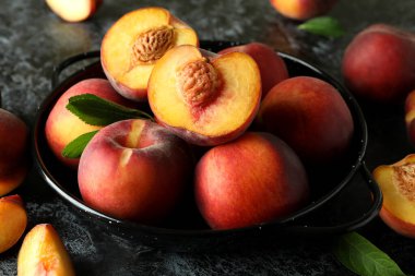 Siyah dumanlı masada şeftali meyveli kase