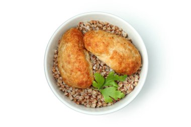 Beyaz arka planda pirzola, karabuğday ve maydanozlu kase.