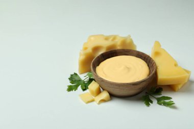 Bir kase peynir sosu ve beyaz arka planda malzemeler.