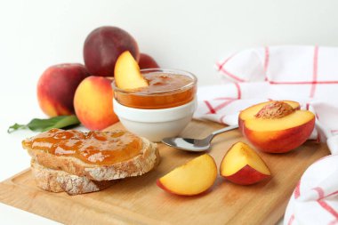 Şeftali reçeli, şeftali reçelli sandviç ve beyaz masada malzemeler.