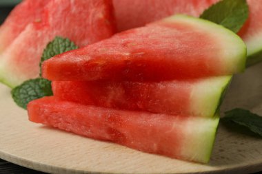 Karpuz dilimleri ve nane yapraklı ahşap tahta.